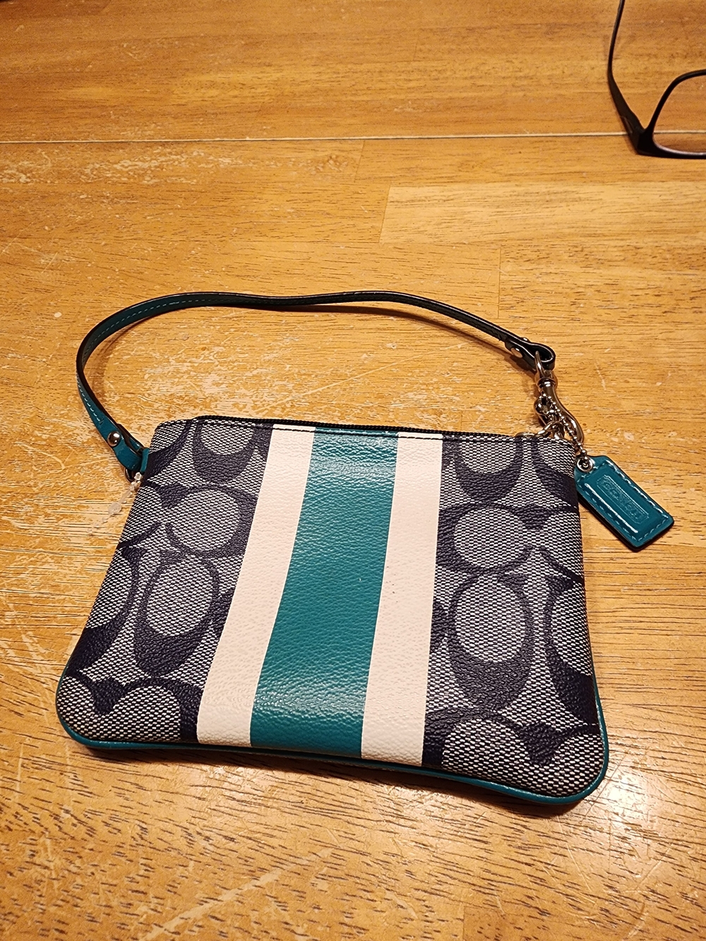 Coach signature coated canvas wristlet with a teal and navy stripe.